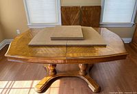 Dining table assembled without leaves, pads on top