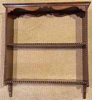 full frontal view of mahogany wall shelf showing three tiers and barley twist supports
