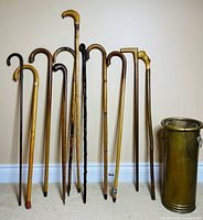 Ten canes lined up beside empty brass stand
