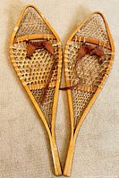 Full view of both wooden snowshoes side by side