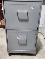 front view showing two drawers, handles, casters, and lock