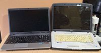 Two laptops side by side, desktop tower visible behind