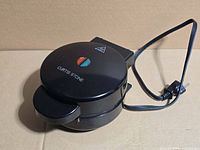 Exterior top view showing brand logo and indicator light of first waffle maker