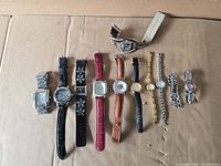 All eleven wristwatches laid out on cardboard