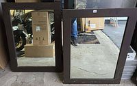 Two brown-framed rectangular mirrors standing side by side
