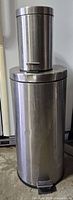 Both stainless steel trash cans stacked, showing full height comparison