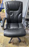 Front view of black faux leather office chair showing seat, backrest and armrests