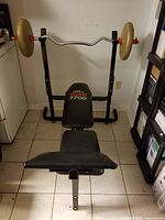 Full view of York 7700 bench with barbell and plates mounted