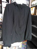Front view of black hooded jacket hanging
