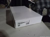 Side of white box showing factory barcode, regulatory symbols, ADT label