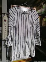Front view of striped blouse on hanger