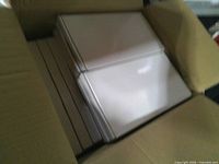 Open shipping carton showing rows of white keyboard boxes