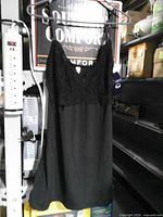 Full view of black Delta Burke lace nightgown hanging on rack