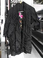 Full view of black crinkle open front top with floral embroidery visible inside