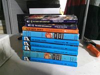 Stack showing all seven Hardy Boys books with titles visible on spines
