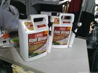 Front view of two Ortho Home Defense Max 1.33-gal jugs showing labels and spray wands