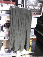 Full view of olive green crinkle skirt hanging