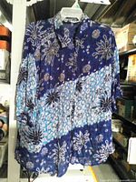 Front view of floral crinkle blouse on hanger