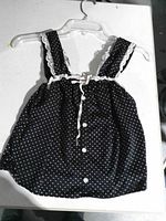 Front view showing polka-dot pattern, buttons, lace trim