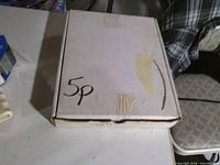 Closed white box marked 5p on table