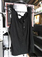 Front view of black Michael Kors tank top hanging on hanger