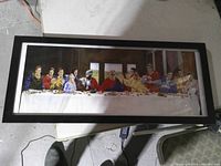 Front view of framed 25-inch Last Supper parody print in black frame
