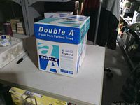 Box of Double A printer paper sitting on table, factory sealed