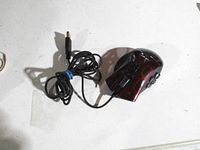 Top view of Razer Naga wired gaming mouse showing red crackle finish, side buttons, attached USB cable