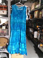 Front view of blue sleeveless dress hanging