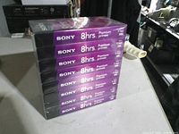 Stack of eight sealed Sony 8-hour Premium VHS tapes, side view shows model T-160 labeling