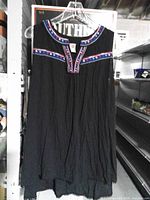 Front view of blouse on hanger showing embroidered neckline and overall style