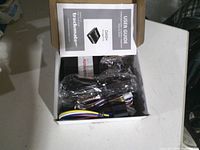 Open box showing tracker module, wiring harness, manual