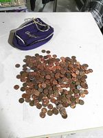Purple Crown Royal pouch lying open beside a pile of assorted pennies