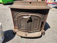 Front view showing arched double doors, ash lip, rust