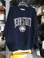 Full view of navy Penn State sweatshirt hanging