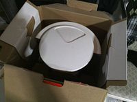 White lid of coffee maker inside opened retail box