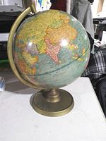 Globe showing Asia, brass-tone meridian and base
