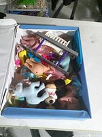 Interior view showing multiple pony figures, accessories and other small toys within case
