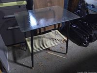 Full view of table showing glass top and lower cord shelf