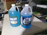 Front view of both sealed 1-gallon jugs showing labels and fluid color