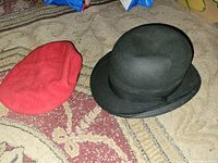 Red Kangol beret and black Wakefield bowler side by side