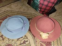 Light blue and dusty rose wool felt hats displayed side by side