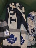 Scarf with team name and logo beside two hats