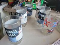 Six Coca-Cola glasses on tabletop