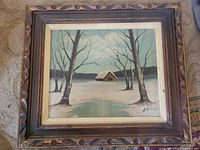 Front view of framed winter landscape painting