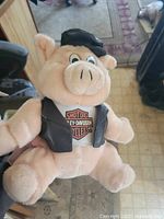 Front view of plush pig showing Harley logo on shirt and outfit