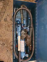 Kit in metal case showing pump, hose, handle and some heads