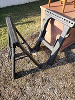Two black Husky folding sawhorses standing outdoors