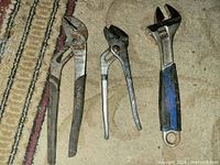 Three hand tools laid side by side on floor