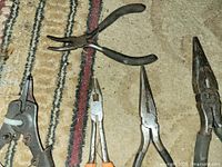 Five pliers laid out on carpet
